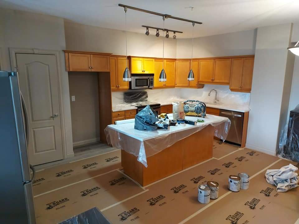 Dated oak kitchen cabinets masked off for repainting
