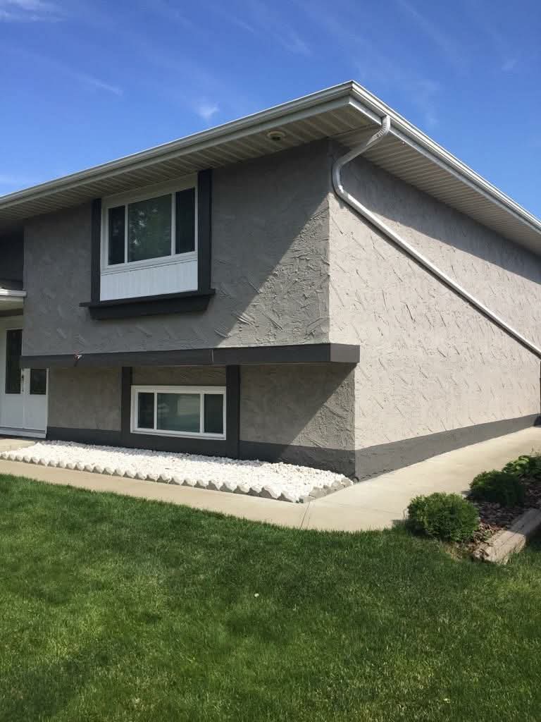 Home exterior after stucco painting in modern grey and charcoal
